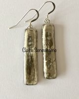 Long silver ceramic earrings.