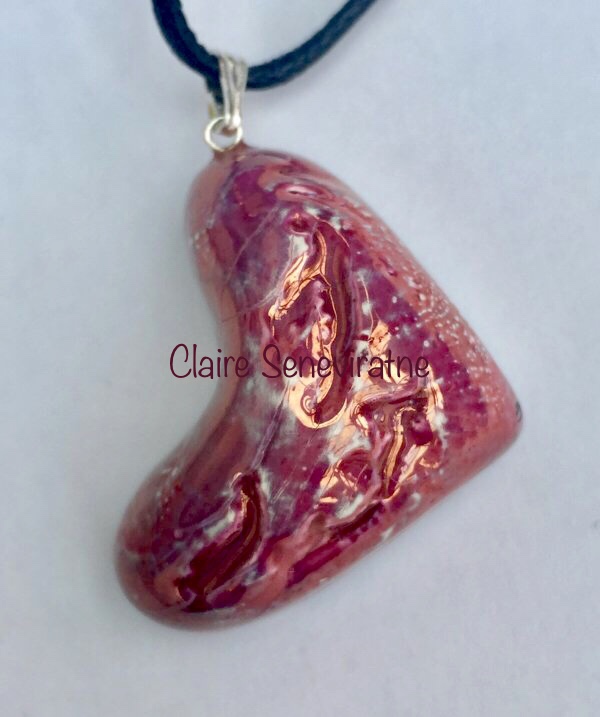 Pink heart pendant hung on its side.