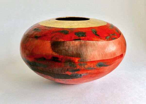 Red smoke-fired pot with gold lustre.