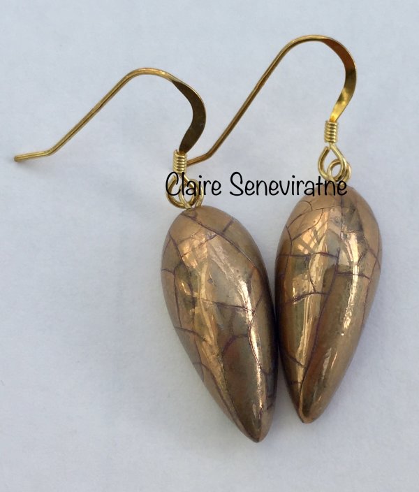 Gold teardrop earrings.