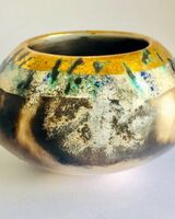 Burnished smoke-fired ceramic pot with gold lustre.