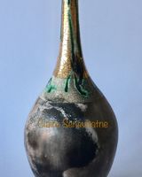 Smoke fired pot with long neck and gold lustre.
