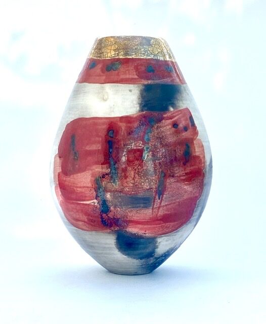 Red smoke-fired pot with gold lustre.