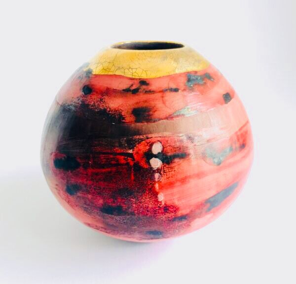 Red smoke-fired pot with gold lustre.