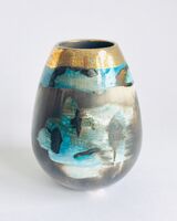 Blue smoke-fired ceramic pot with glaze and gold lustre.