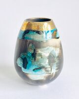 Blue smoke-fired ceramic pot with glaze and gold lustre.