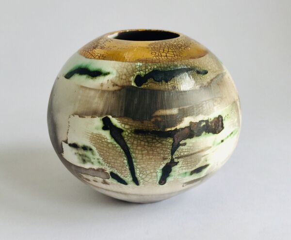 Burnished smoke-fired ceramic pot with gold lustre.