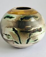 Burnished smoke-fired ceramic pot with gold lustre.