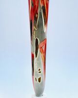 Tall smoke-fired pot with red glaze and gold lustre.