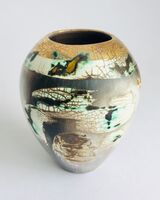 Burnished smoke-fired ceramic pot with gold lustre.