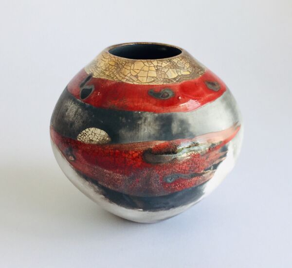 Red smoke-fired pot with gold lustre.