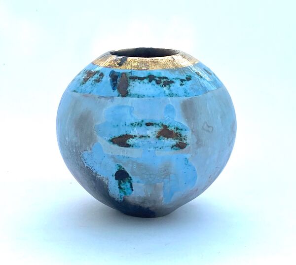 Small round blue smoke-fired ceramic pot with gold lustre.