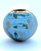 Small round blue smoke-fired ceramic pot with gold lustre.