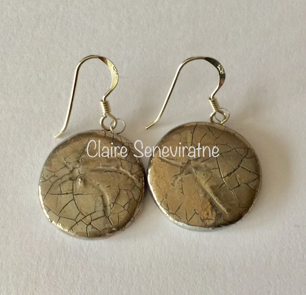 Round ceramic earrings with silver lustre.