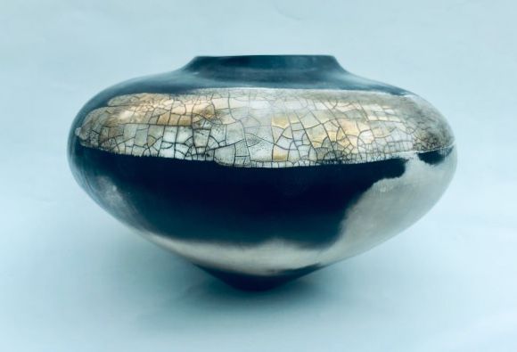 Round smoke-fired porcelain vessel with gold lustre.