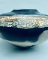Round smoke-fired porcelain vessel with gold lustre.