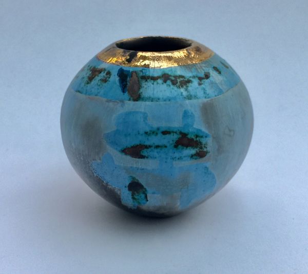 Small round blue smoke-fired ceramic pot with gold lustre.