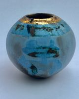 Small round blue smoke-fired ceramic pot with gold lustre.