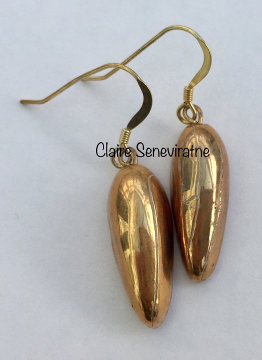 Gold teardrop earrings.