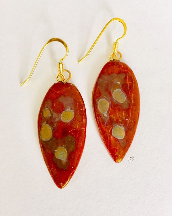 Red leaf shaped ceramic drop earrings with matt gold patterns.