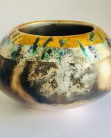 Burnished smoke-fired ceramic pot with gold lustre.