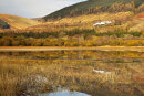 A train on Brecon Mountain Railway reflected in Pontsticill Reservoir.