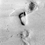 abstract black and white photograph of wave washed footprints on a sandy beach in Lagos, Portugal