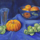 Blue, Orange and Green A still life featuring sprouts, a mini pumpkin and a tall glass on blue fabric. On a higher fabric-covered platform is a blue bowl with small oranges in it.