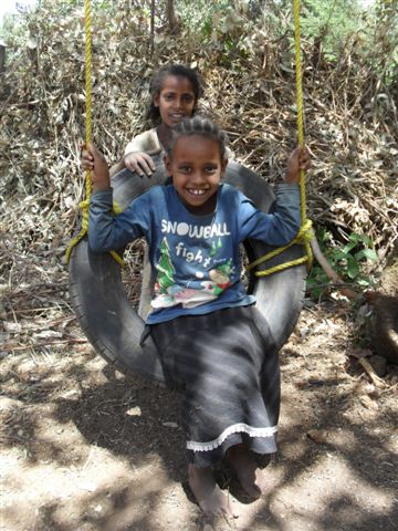 schoolgirls enjoy playing on the swing