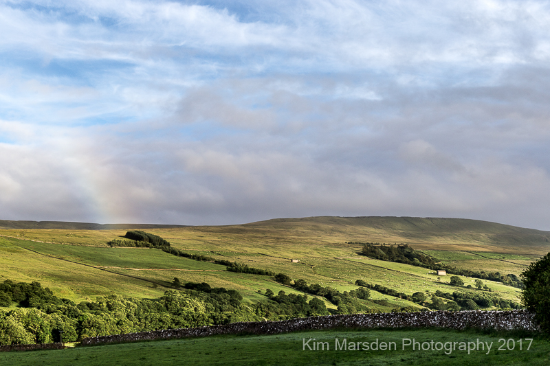 Coverdale in late evening light with the end of a rainbow