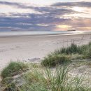 Early morning sun breaking through over Farne Islands from Bamburgh beach