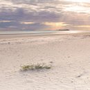 Early morning sun breaking through over Farne Islands from Bamburgh beach
