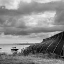 Lindisfarne boat with Bamburgh Castle in the distance - mono