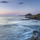 Bamburgh Castle lit by pre-dawn light