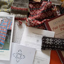 Close up of a jumble of knitting patterns, swatches and maths notes.