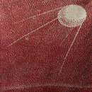 Knitted picture of Sputnik 1 satellite in red and dark cream