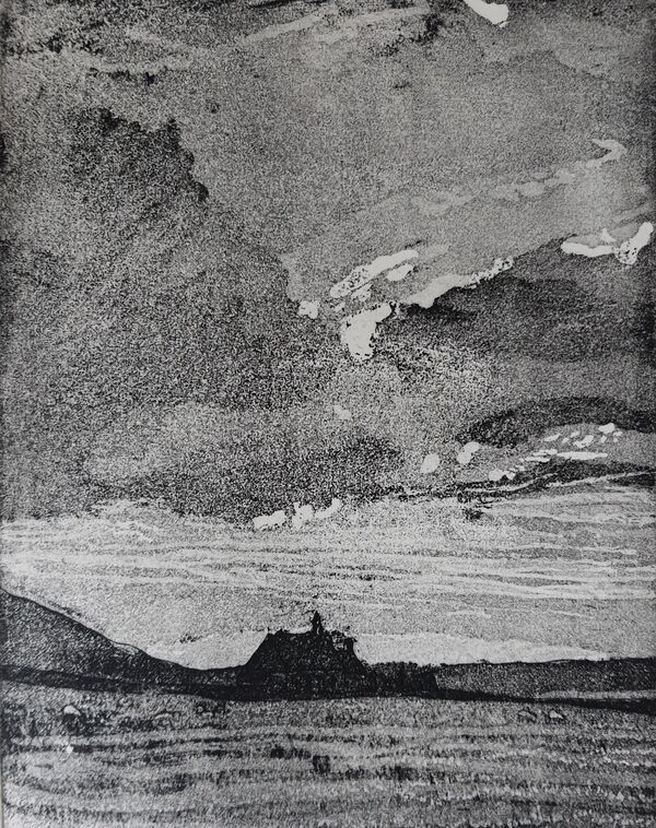 black and white with a cloudy sky  - a dark building stands out in the middle ground.  The foreground is textured