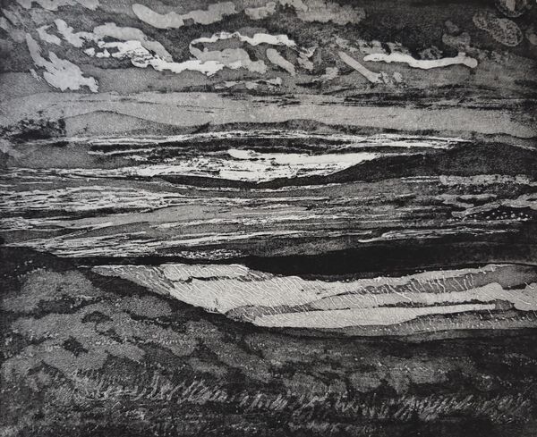 cloudy sky rough sea with sunlight rocky islets and a grassy foreground black and white
