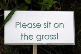 Sign saying Please Sit on the Grass