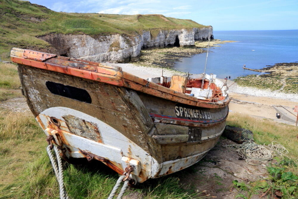 Flamborough North Landing with rotting fishing-boat and limestone cliffs