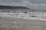Surf on beach at Port Eynon, Gower, under stormy sky