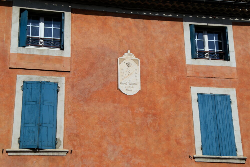 Sundial with Latin motto and shutters on house at Sainte-Cécile-les-Vignes