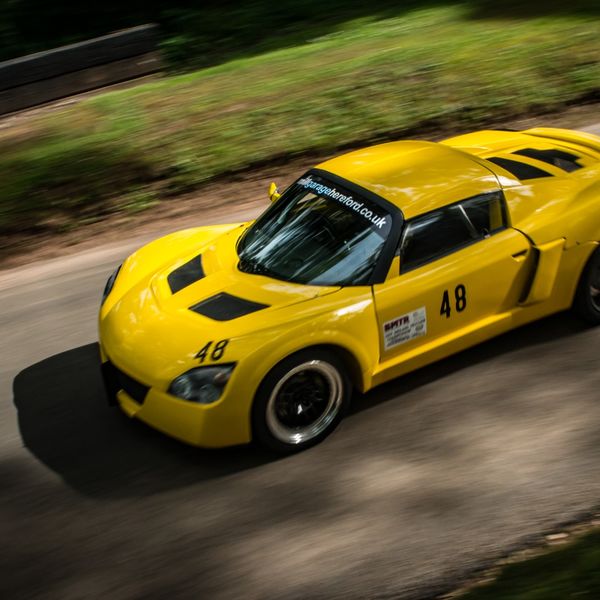 Best of British 2019, Shelsley Walsh, #62 yellow vauxhall vx220 race car descending shelsley walsh hill at speed