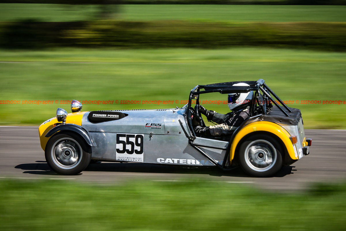 Yellow and silver Caterham 7 at speed along the Curborough sprint course shenstone straight