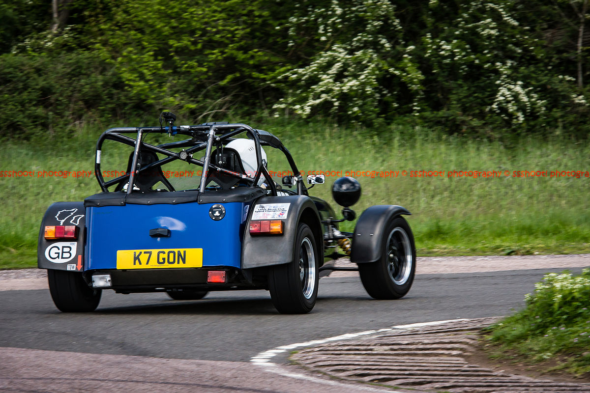 Blue Caterham 7 at speed round flag pole corner at shenstone sprint course