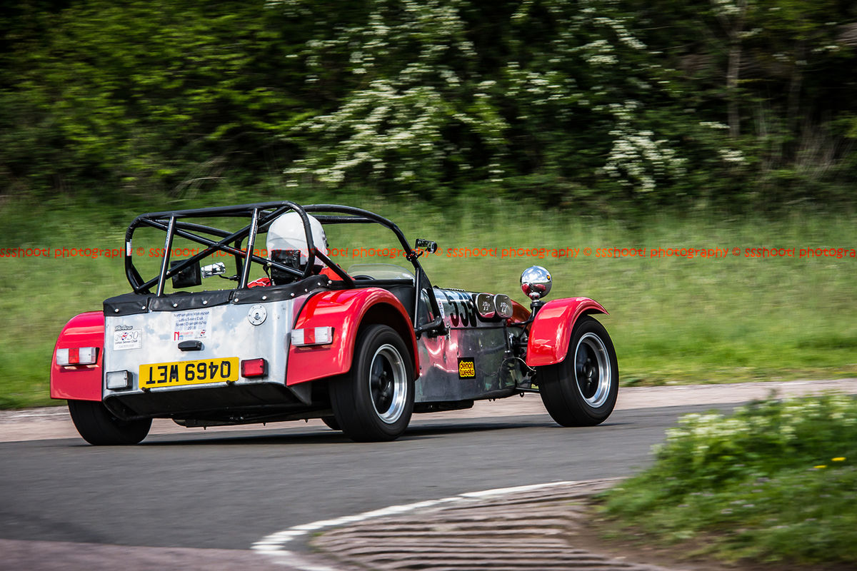 Red Caterham 7 at speed round flag pole corner at shenstone sprint course