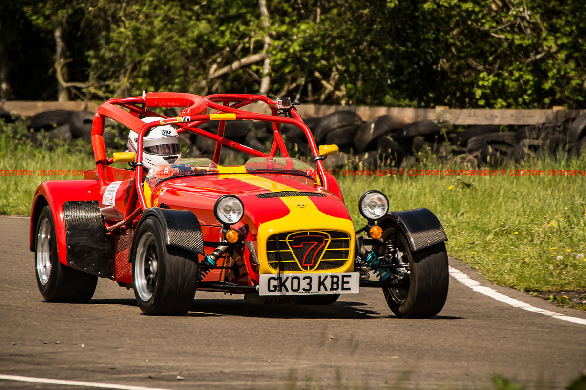 red and yellow caterham 7 at speed through curborough sprint course mole hill corner