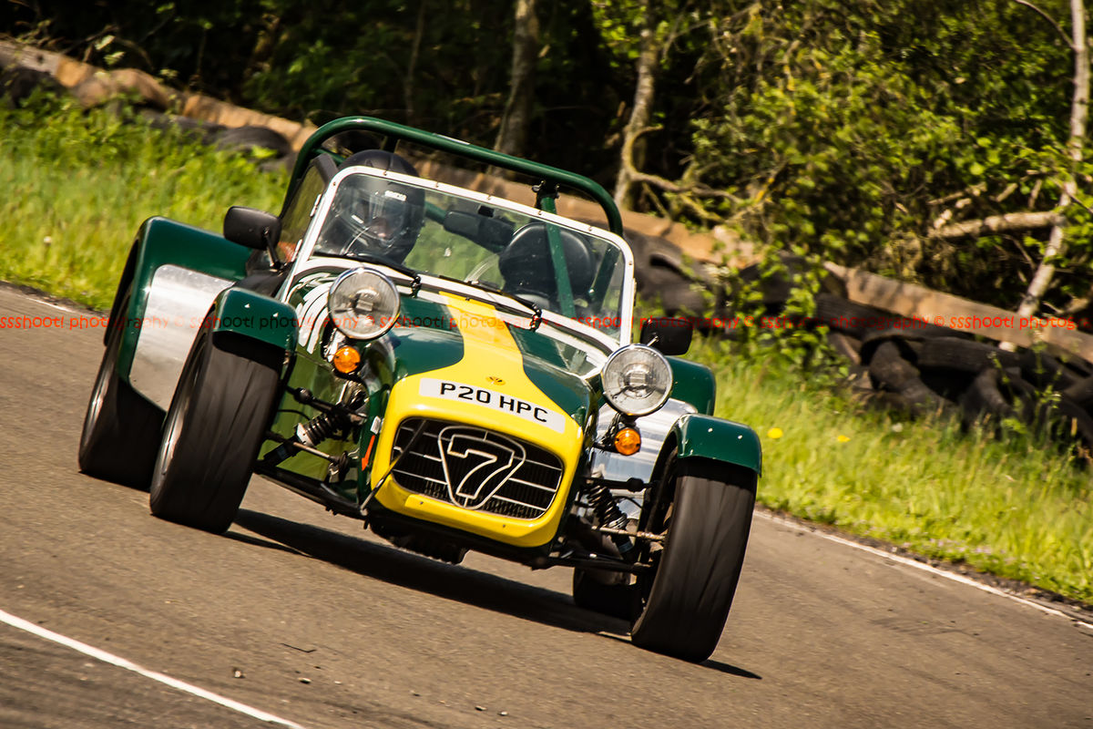 green and yellow caterham 7 at speed through curborough sprint course mole hill corner