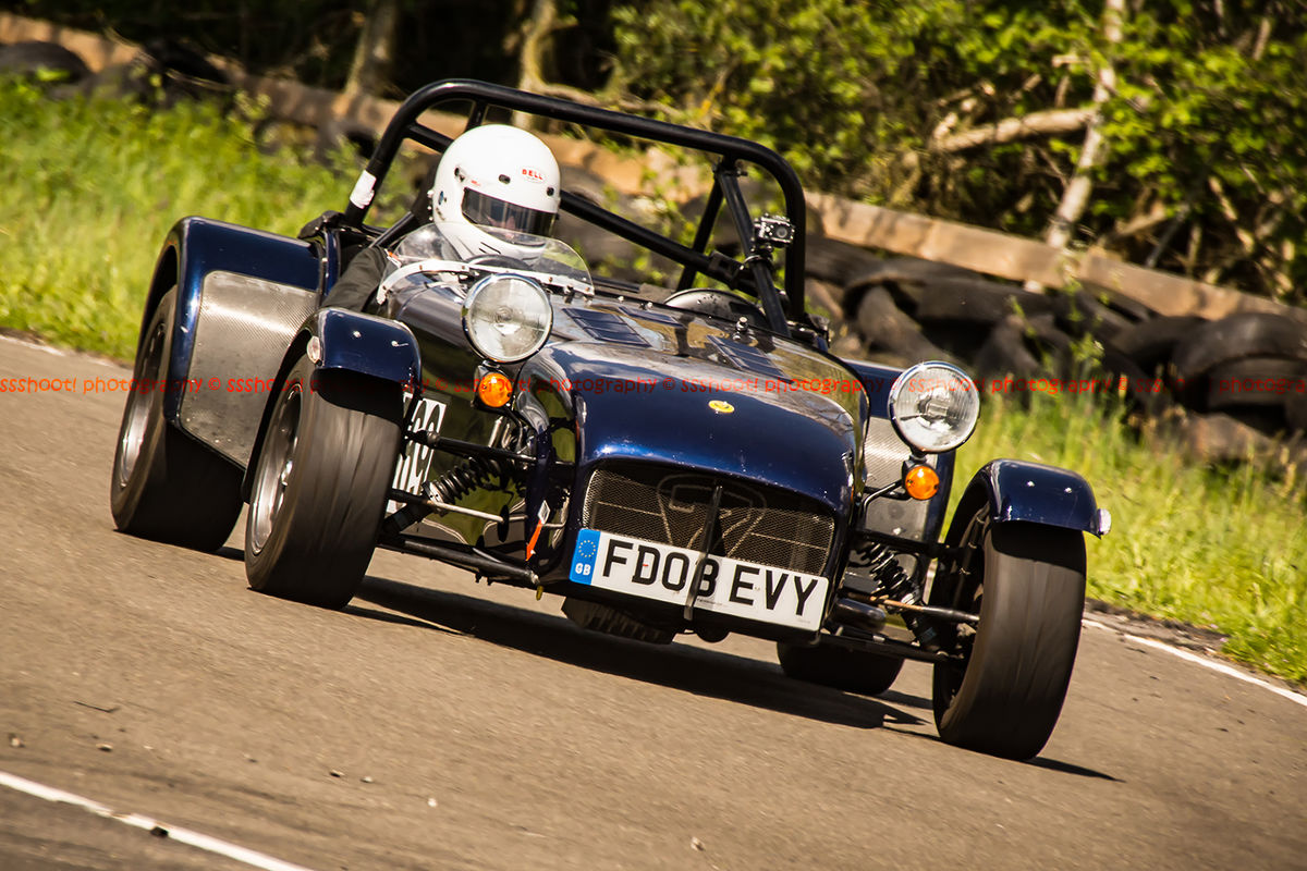 dark blue caterham 7 at speed through curborough sprint course mole hill corner