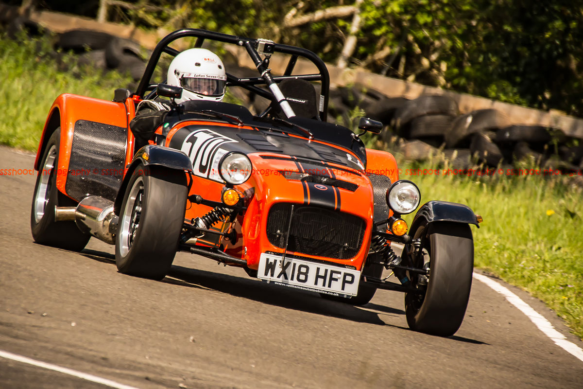 orange caterham 7 at speed through curborough sprint course mole hill corner